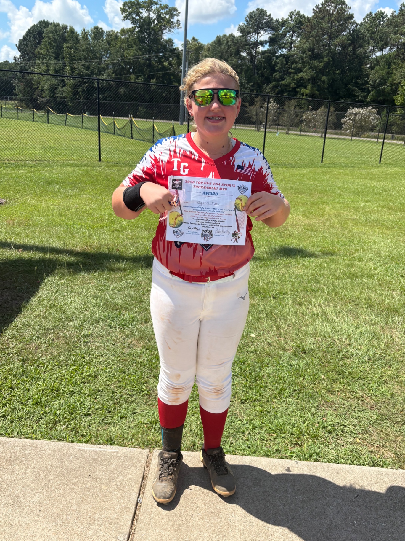 Hayden Mass on the field holding her 2026 Top Gun USA Sports Tournament MVP award certificate.